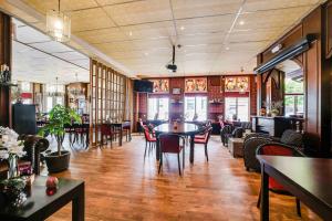 a restaurant with tables and chairs in a room at Hotel Heerenlogement in Harlingen