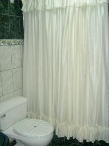 a bathroom with a white shower curtain and a toilet at HOSTAL MONUMENTAL a Media Cuadra de la Plaza Mayor in Cajamarca