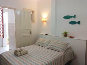 une chambre avec un lit avec une couverture rayée et une porte dans l'établissement Suítes Recanto cama e café, à Arraial do Cabo