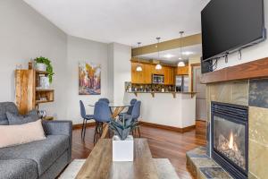 un soggiorno con divano e camino di Alluring Mountain View Condo -Right In The Heart Of Downtown!! Hosted by Fenwick Vacation Rentals a Canmore