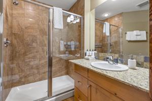 坎莫尔Alluring Mountain View Condo - Right In The Heart Of Downtown - managed by Little Sister Getaways的带淋浴和水槽的浴室 更多24张照片