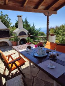 a table and chairs on a patio with a fireplace at Petrichor houses in Portariá