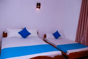 - deux lits assis l'un à côté de l'autre dans une pièce dans l'établissement Blue Waves Madiha, à Matara