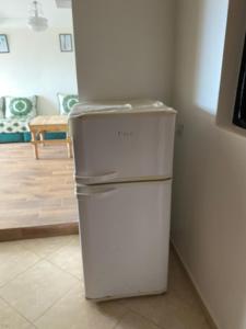 ein weißer Kühlschrank in einer Ecke des Zimmers in der Unterkunft Imsouanegreenwave in Imsouane