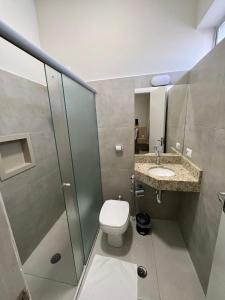 a bathroom with a toilet and a sink and a shower at Santa Rosa Hotel in Assis