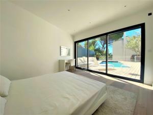 a bedroom with a large white bed and a large window at Villa Marine - 10 pers - Centre Cassis - Piscine in Cassis