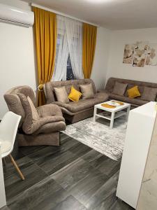 uma sala de estar com dois sofás e uma mesa em Elif Apartman em Novi Pazar