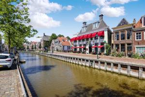 a canal in a town with buildings and a street at Hotel Restaurant 't Heerenlogement in Harlingen