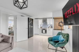 ein Wohnzimmer mit einem grünen Stuhl und eine Küche in der Unterkunft Modern Apartment in Wymondham in Wymondham