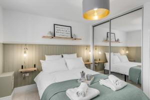 een slaapkamer met 2 bedden en handdoeken op een groene deken bij Modern Apartment in Wymondham in Wymondham