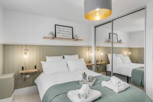 a bedroom with two beds with towels on a green blanket at Modern Apartment in Wymondham in Wymondham