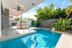 a swimming pool in the backyard of a house at Poolside Gunya Luxury Living in Fannie Bay in Fannie Bay
