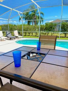 a wooden table with blue cups on it next to a pool at DWS Vacation Villas in Orlando