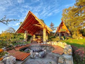 a house with a deck and a fire pit at Rustic cottage JARILO, an oasis of peace in nature in Ležimir