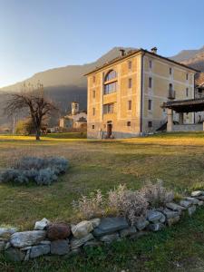 un gran edificio en un campo con una pared de piedra en Sassiglioni Vacanze, en Sassiglioni