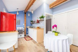 cocina con mesa blanca y nevera roja en Adorable & Pet Friendly-Close to U and Downtown!, en Salt Lake City