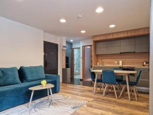 a living room with a blue couch and a table at Royal Maison Apartments in Cluj-Napoca