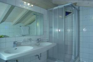 a white bathroom with a sink and a shower at Appartement Residenz Klabacher in Mittersill