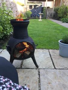 una estufa negra con fuego en un patio en Mews Cottage Arnside - 2 Bedroom Cottage en Arnside