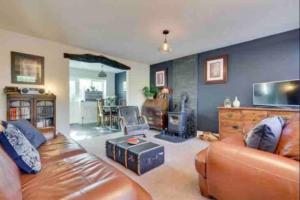 uma sala de estar com um sofá de couro e uma lareira em Mews Cottage Arnside - 2 Bedroom Cottage em Arnside
