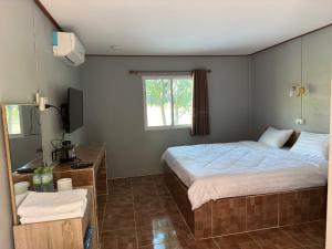 a bedroom with a large bed and a window at สวนสบายปลายนารีสอร์ท in Ban Hin Lat