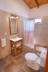 a bathroom with a toilet and a sink at Altos del Rio (Solo parejas) in Los Reartes