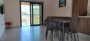 ein Esszimmer mit einem Tisch und Stühlen sowie einem Balkon in der Unterkunft Limeria in Alona