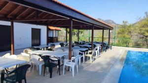 a row of tables and chairs next to a swimming pool at Limeria in Alona