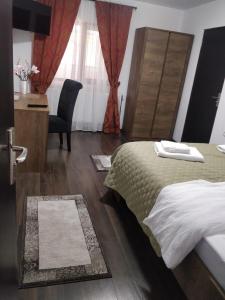 a bedroom with a bed and a desk and a chair at Casa Marina in Călimăneşti +2 photos