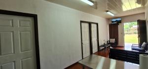 a room with a white wall and a door and a table at Sleep&Go! Apartamento de 2 habitaciones doble aire acondicionado en Siquirres in Siquirres