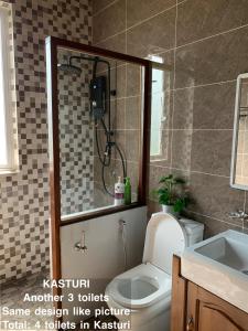 a bathroom with a shower and a toilet and a sink at TUAH AND KASTURI D MANGGIS JANDA BAIK PRIVATE SWIMMING POOL MAGNIFICENT HILL VIEW 2 Different unit in Bentong