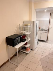 a kitchen with a microwave and a refrigerator at Departamentos MITRE in Mendoza