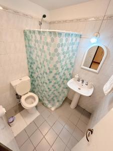 a bathroom with a toilet and a sink and a mirror at Departamentos MITRE in Mendoza