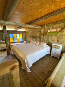 Un dormitorio con una cama en una cabaña de madera. en Cabaña de Silvina, en La Pedrera