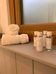 a bathroom counter with bottles of lotion and a towel at Hascombe Accommodation in Hascombe