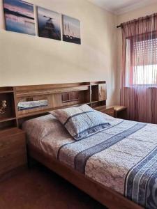 een slaapkamer met een bed met een houten hoofdeinde bij Cardoso House VPA in Vila Praia de Âncora
