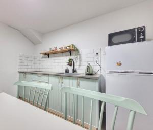 a kitchen with mint green cabinets and a refrigerator at בית בלב הגולן in Qasrîne