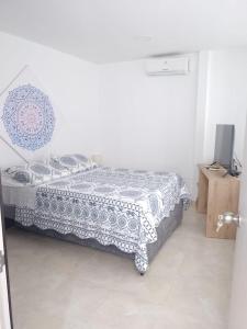 1 dormitorio con 1 cama con manta azul y blanca en PARK 83 Apartaestudios, en Cali