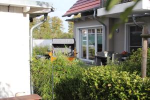 uma casa com um jardim com um banco no quintal em Ferienwohnung Stoneyard´s em Wustrow