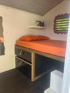 uma cama num quarto com uma mesa de madeira em Ride In Youth and Surf Center em Morne-à-lʼEau