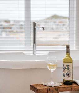 a bottle of wine and a glass on a table at Harbour View House in St Ives