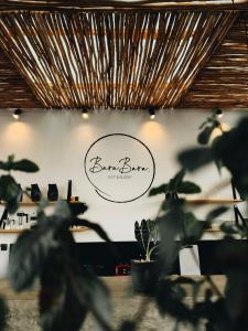 a sign on the wall of a barbershop with plants at BaraBara Eat&Sleep - Eco Boutique Hotel in Paje