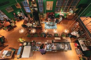 una vista in alto di un ristorante con una donna in piedi al bancone di OrigInn Space a Taipei Altre 37 foto