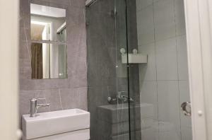 bagno con doccia, lavandino e specchio di Residencial Frank I a Santo Domingo