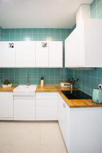a kitchen with white cabinets and a sink at VisHostel in Viseu