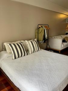 1 cama con almohadas blancas y negras en una habitación en Studio Torre Rio - IMPECABLE STUDIO, LUMINOSO, CHIC - EXCELENTE UBICACIÓN - PALERMO en Buenos Aires