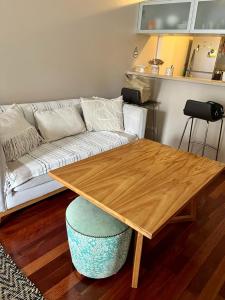 a living room with a wooden table and a couch at Studio Torre Rio - IMPECABLE STUDIO, LUMINOSO, CHIC - EXCELENTE UBICACIÓN - PALERMO in Buenos Aires