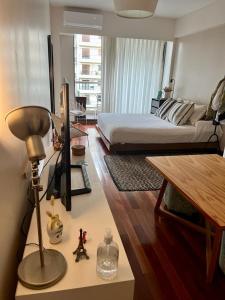 um quarto com uma cama e uma secretária com um candeeiro em Studio Torre Rio - IMPECABLE STUDIO, LUMINOSO, CHIC - EXCELENTE UBICACIÓN - PALERMO em Buenos Aires