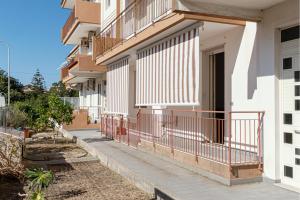 un bâtiment avec balcon et un trottoir en face de celui-ci dans l'établissement Seashore House - Appartamento a 100 mt dal mare, à Villafranca Tirrena