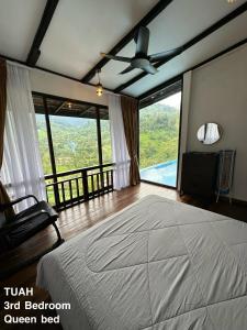 een slaapkamer met een groot bed en grote ramen bij TUAH AND KASTURI D MANGGIS JANDA BAIK PRIVATE SWIMMING POOL MAGNIFICENT HILL VIEW 2 Different unit in Bentong